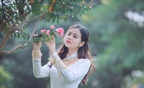 mulher olhando flor de arvore