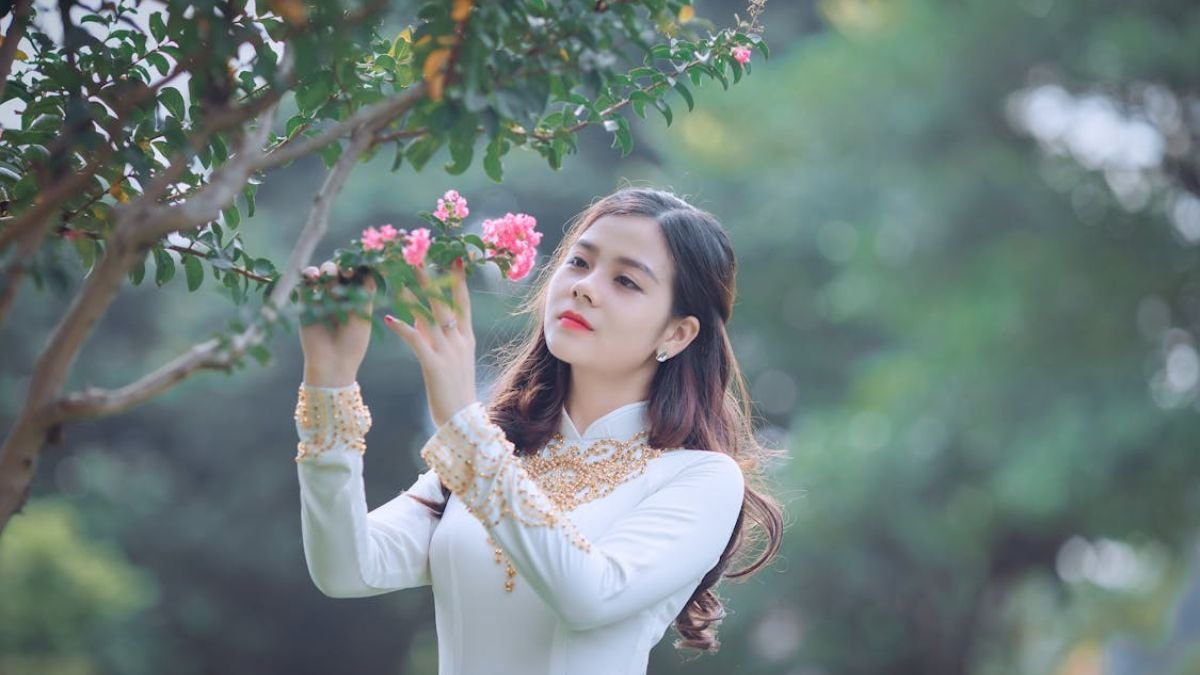 mulher olhando flor de arvore